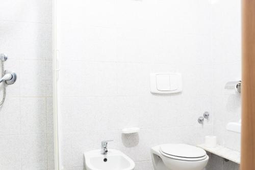 a white bathroom with a toilet and a sink at Banchi Centrale in Riomaggiore
