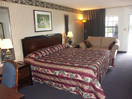 Habitación de hotel con cama y sofá en Deerwood Inn & Madison Campground, en Madison