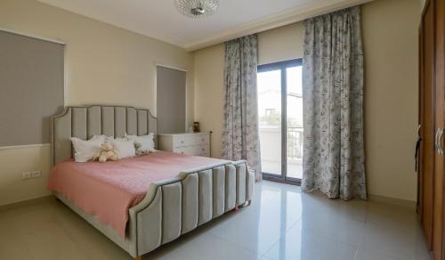 - une chambre avec un grand lit et une grande fenêtre dans l'établissement Spacious,amazing villa with a beautiful blooming garden!, à Dubaï
