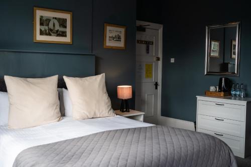 1 dormitorio con 1 cama con pared azul en The Plough Itchen Abbas, en Winchester