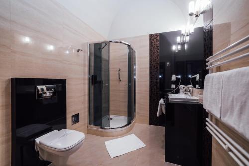 uma casa de banho com um chuveiro, um WC e um lavatório. em Hotel Rezydent em Cracóvia
