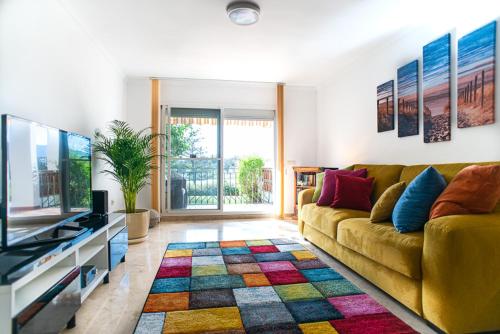 ein Wohnzimmer mit einem Sofa und einem TV in der Unterkunft Sunset apartment, front line Mijas Golf in Mijas