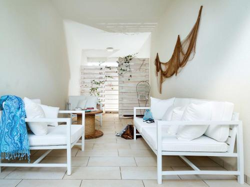 a room with two white chairs and a table at Lisca Bianca in San Vito lo Capo