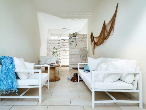 サン・ヴィート・ロ・カーポにあるLisca Biancaの白い椅子2脚とテーブルが備わる客室です。