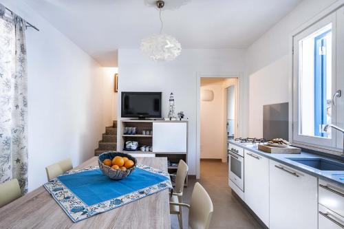a kitchen with a table with a bowl of oranges on it at Lisca Bianca in San Vito lo Capo
