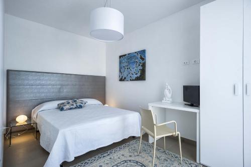 a bedroom with a bed and a desk and a television at Lisca Bianca in San Vito lo Capo