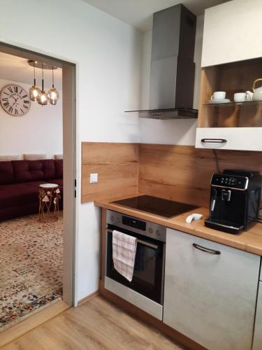 a kitchen with a stove top oven next to a living room at Moderne 3Zimmer Wohnung, in Königsbrunn bei Augsburg in Königsbrunn