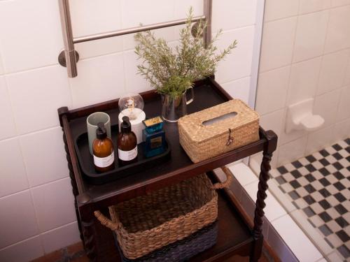 a shelf in a bathroom with bottles and a basket at Daisy Cottage in Nieu-Bethesda