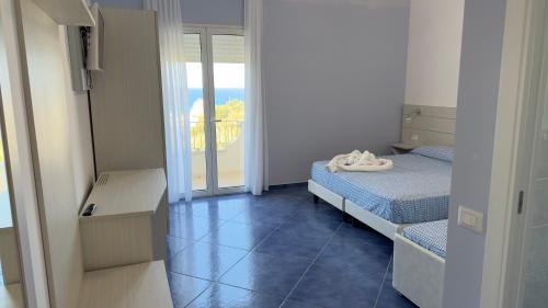 - une petite chambre avec un lit et un balcon dans l'établissement Hotel La Giara, à Zambrone