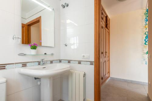 a white bathroom with a sink and a mirror at Villa Kristi 9 pers privat pool in Calonge