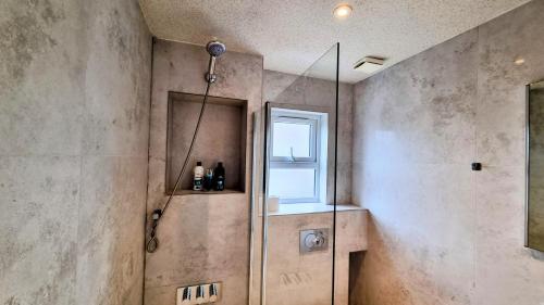 a shower in a bathroom with a window at Surbiton Luxury Garden House 19 in Surbiton