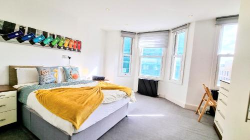 Un dormitorio con una cama con una manta amarilla. en Surbiton Luxury Garden House 19 en Surbiton