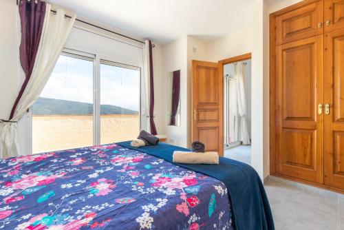 a bedroom with a bed and a large window at Villa Kristi 9 pers privat pool in Calonge