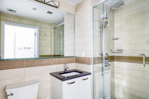 une salle de bain avec un lavabo et une douche dans l'établissement Amazing Midtown W 1BR w Gym nr Times Sq NYC-650, à New York