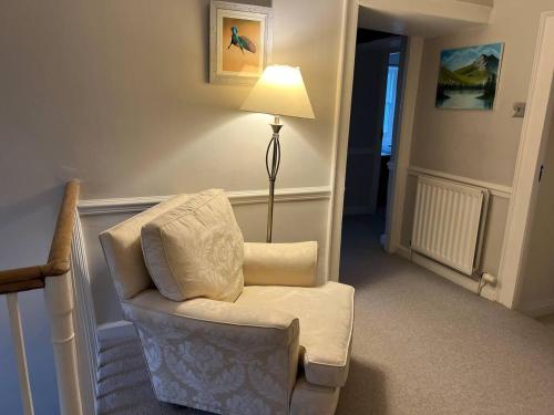 a living room with a chair and a lamp at Stunning 4 bed Grade house in the Lake District in Wigton