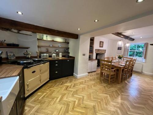 a large kitchen with a table and a dining room at Stunning 4-bed Grade II house in the Lake District in Wigton