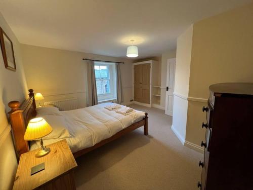 a bedroom with a bed and a table with a lamp at Stunning 4 bed Grade house in the Lake District in Wigton