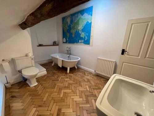 uma casa de banho com uma banheira, um WC e um lavatório. em Stunning 4-bed Grade II house in the Lake District em Wigton