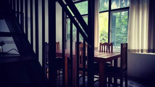 a wooden table and chairs in a room with a window at Riverston Nature Villa in Rattota