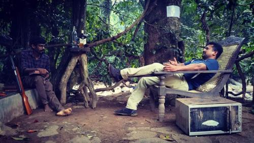 two men sitting on a bench in a forest at Riverston Nature Villa in Rattota