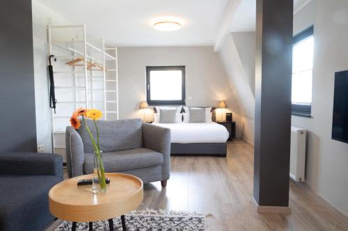 uma sala de estar com um sofá e uma cama em Apex Nürburg em Nürburg