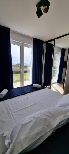 a bedroom with a large bed with blue curtains at Apartman Gaby in Podstrana