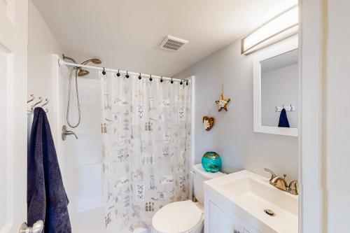 ein weißes Bad mit einem Duschvorhang und einem Waschbecken in der Unterkunft Montego Bay - Atlantic 13300 in Ocean City