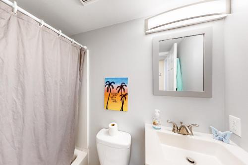 a bathroom with a toilet and a sink and a mirror at Montego Bay - Atlantic 13300 in Ocean City