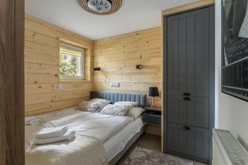 ザコパネにあるW Rent like home - Gimnazjalnaの木製の壁のベッドルーム1室(ベッド1台付)