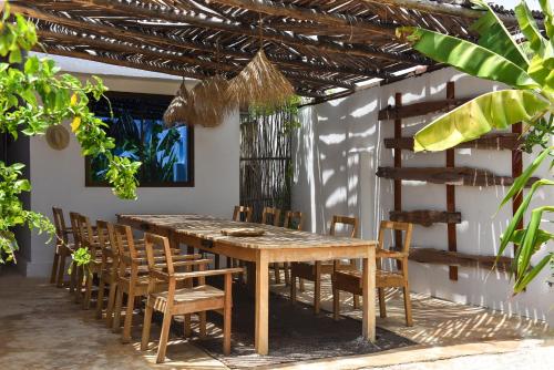 Dar Mar Hostel & Coworking في باجي: غرفة طعام مع طاولة وكراسي خشبية