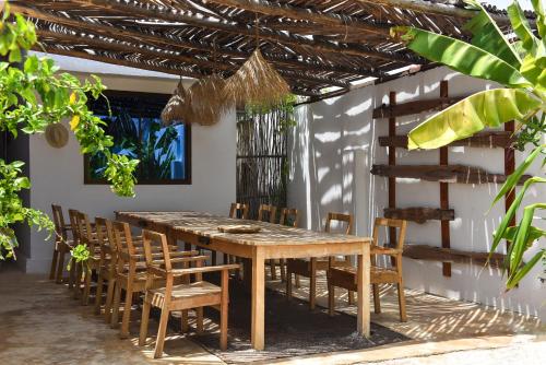 a dining room with a wooden table and chairs at Dar Mar Hostel & Coworking in Paje