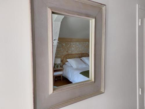 a mirror reflecting a bed in a bedroom at Le Poutic gîte et maison d'hôtes in Créon-dʼArmagnac