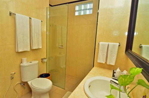 a bathroom with a shower and a toilet and a sink at Inna Sindhu Beach Hotel & Resort in Sanur