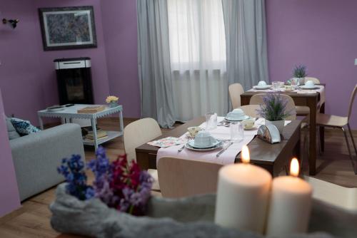 a living room with purple walls and tables and candles at B&B Casa Caporali in Fabriano