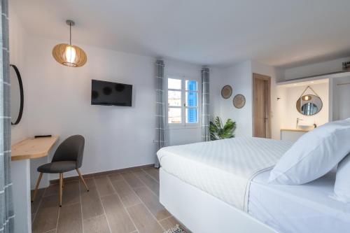 ein weißes Schlafzimmer mit einem Bett und einem Schreibtisch in der Unterkunft Luxury Apartment En Lefko in Poros