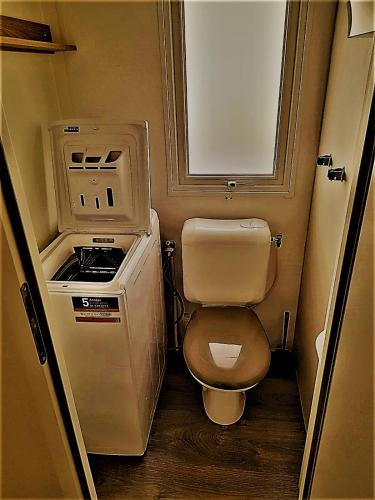 Elle comprend une petite salle de bains pourvue de toilettes et d'une cuisinière. dans l'établissement MOBIL HOME Tendance Tout Confort - FUNPASS non included, à Gastes