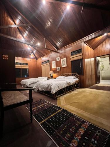 een kamer met twee bedden en een tafel erin bij Log Cabin Mountain View Tugu Selatan Cisarua in Campaka