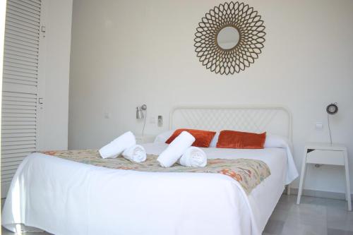 een witte slaapkamer met een wit bed met rode kussens bij Living Sevilla Apartments Catedral in Sevilla