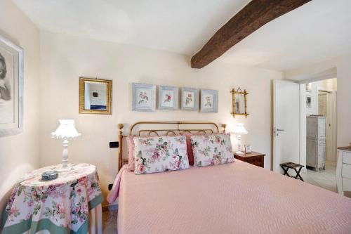 a bedroom with a pink bed and a table at Casa dei Tigli in Ormea