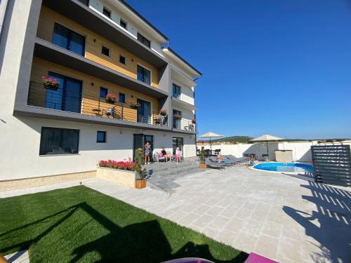 a large apartment building with a patio and a swimming pool at Pensiunea NOVO in Baile Felix