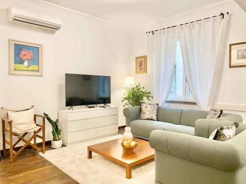 uma sala de estar com um sofá e uma televisão em Vintage Top Centre Apartment em Sófia