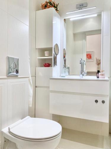 a white bathroom with a sink and a toilet at Vintage Top Centre Apartment in Sofia