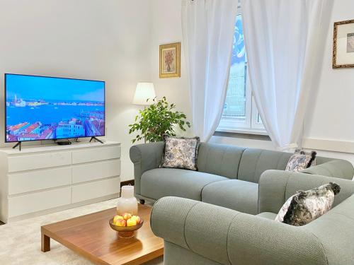 ein Wohnzimmer mit Sofa und Fernseher in der Unterkunft Vintage Top Centre Apartment in Sofia
