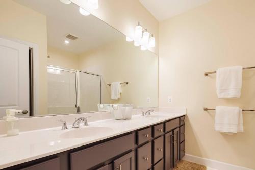 a bathroom with two sinks and a large mirror at Capital Courts End unit My Luxe. in Upper Marlboro