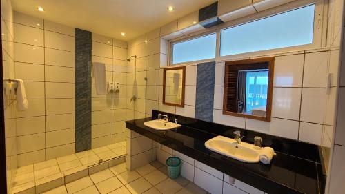 baño con 2 lavabos y ventana en c3 Cowrie Shell Residences en Mombasa