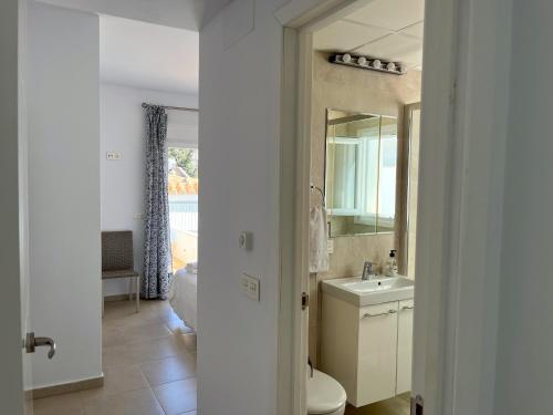 a bathroom with a sink and a toilet and a mirror at Nerja Paradise Rentals - Villa Zafiro in Nerja