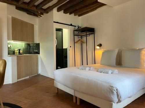1 dormitorio con 1 cama blanca grande y toallas. en Conde Chic Studio en París
