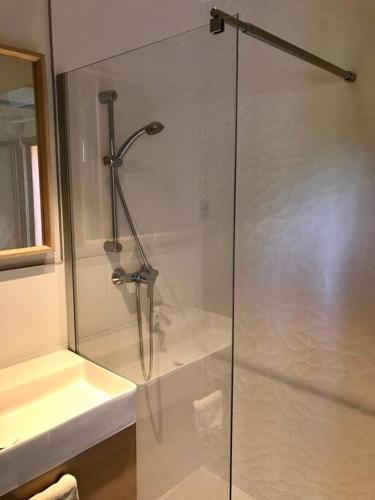une douche en verre dans une salle de bain avec un lavabo dans l'établissement Beauregard Cévennes - Superbe chambre d'hôtes moderne et indépendante, à Monoblet