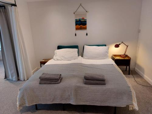 a bedroom with a bed with two towels on it at Beech House 20 minute walk to Airport in Bristol