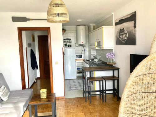 uma cozinha e sala de estar com uma mesa e um frigorífico em Rincon en el Rio Sella em Ribadesella